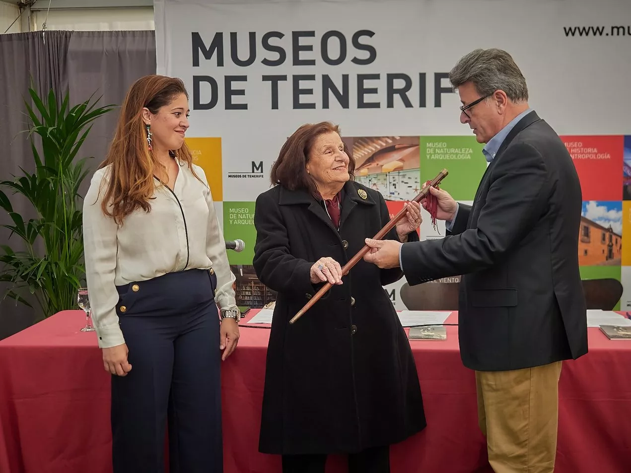El consejero de Cultura y Museos de Tenerife, José Carlos Acha, recibe la vara de manos de Concha Mendoza./ CEDIDA