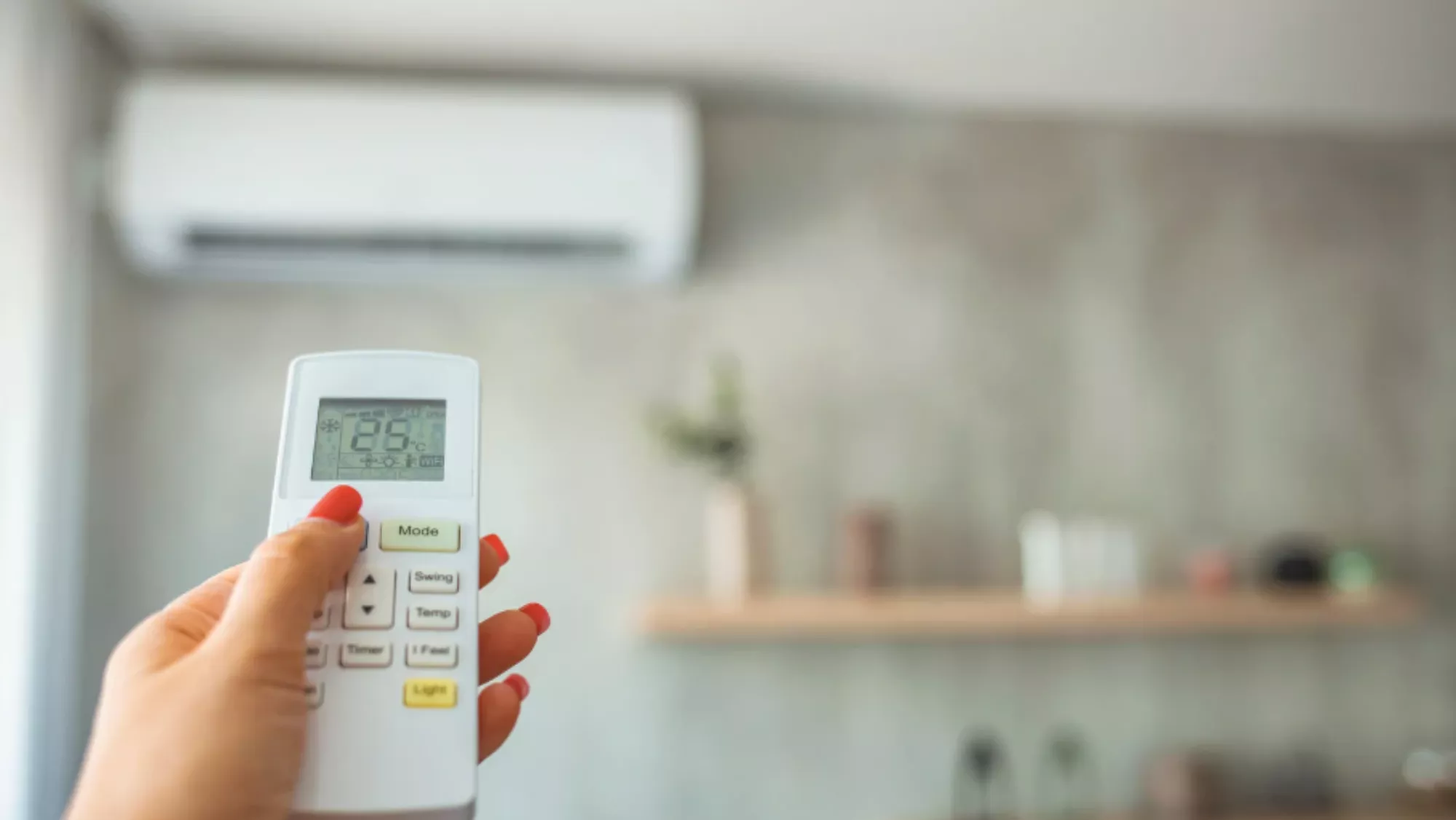 Imagen de una mujer encendiendo el aire acondicionado por el calor / AH