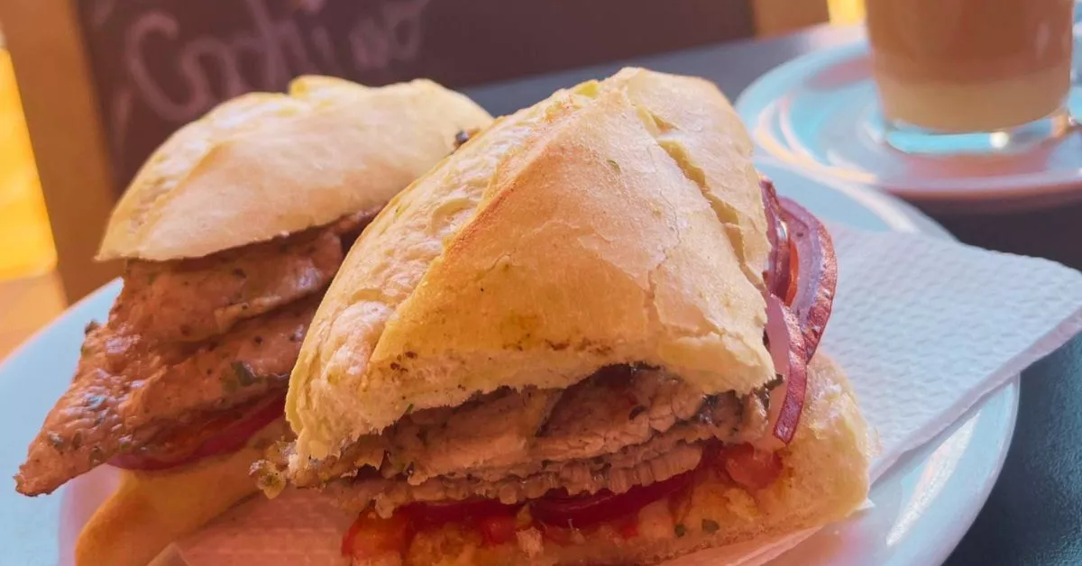 El bocadillo de cochino del bar La Terraza de La Recova viene con cebolla roja, tomate y mojo rojo./ AH.