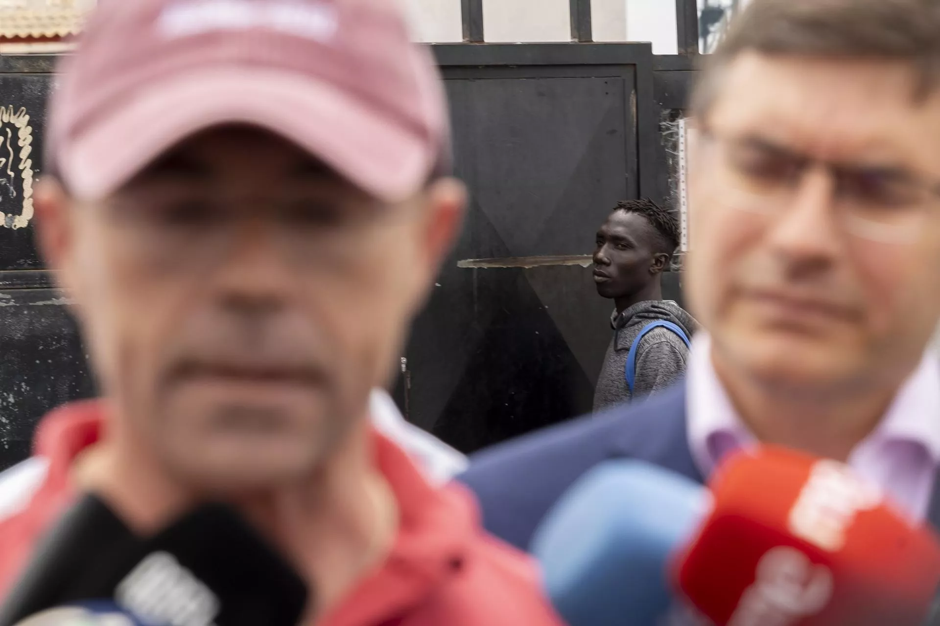 La desbandada de Vox en Canarias: fugas, crisis interna y la sombra ultracatólica. En la imagen, un interno del centro de acogida del Canarias 50 observa a Jorge Buxadé y Nicasio Galván. / QUIQUE CURBELO-EFE