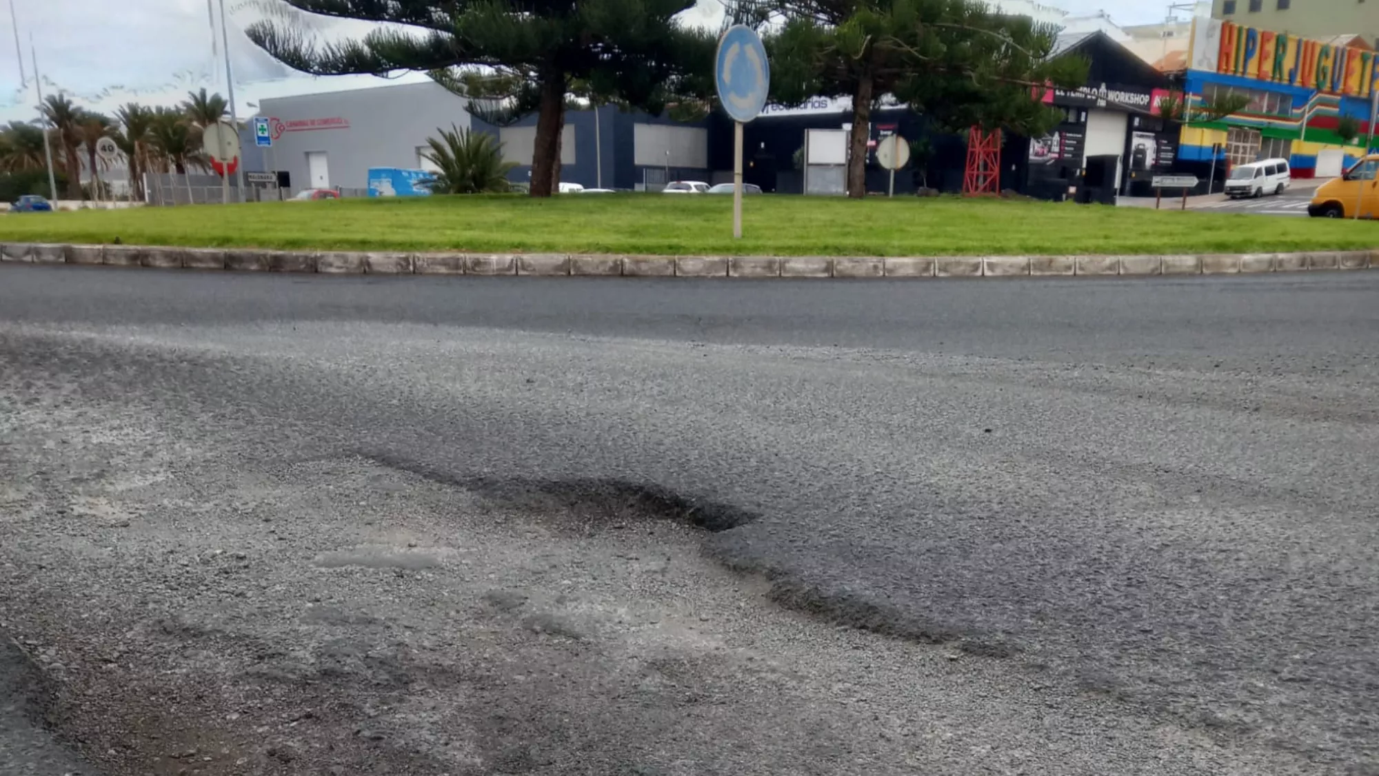 Un bache de los múltiples que presenta la carretera de acceso al polígono de Salinetas, en Telde./ REDES