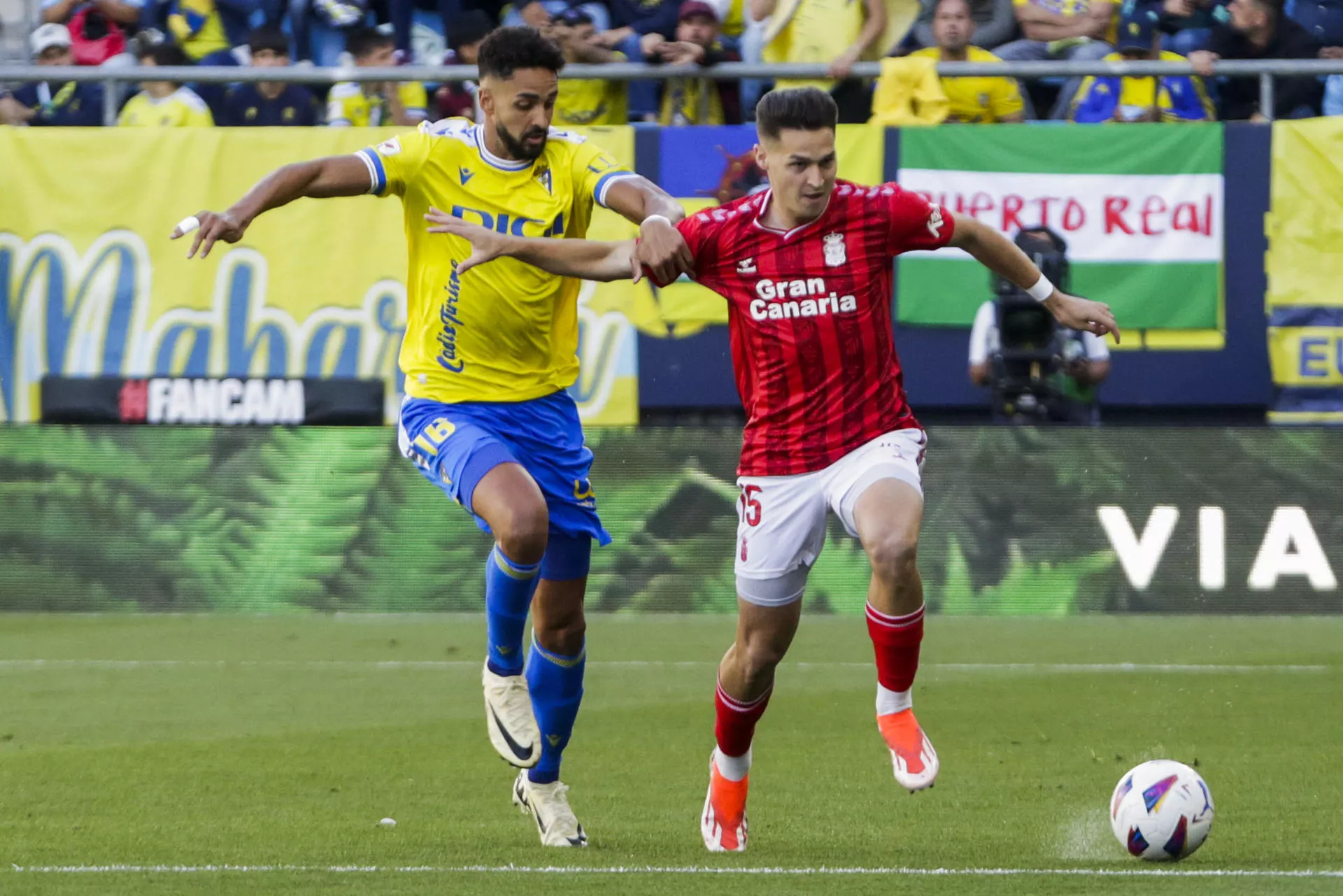 El defensa de la UD Las Palmas, Mika Mármol (d), trata de escapar de Chris Ramos, del Cádiz, durante el partido de Liga en Primera División que Cádiz CF y UD Las Palmas disputan este domingo en el estadio Nuevo Mirandilla. / EFE - ROMÁN RÍOS