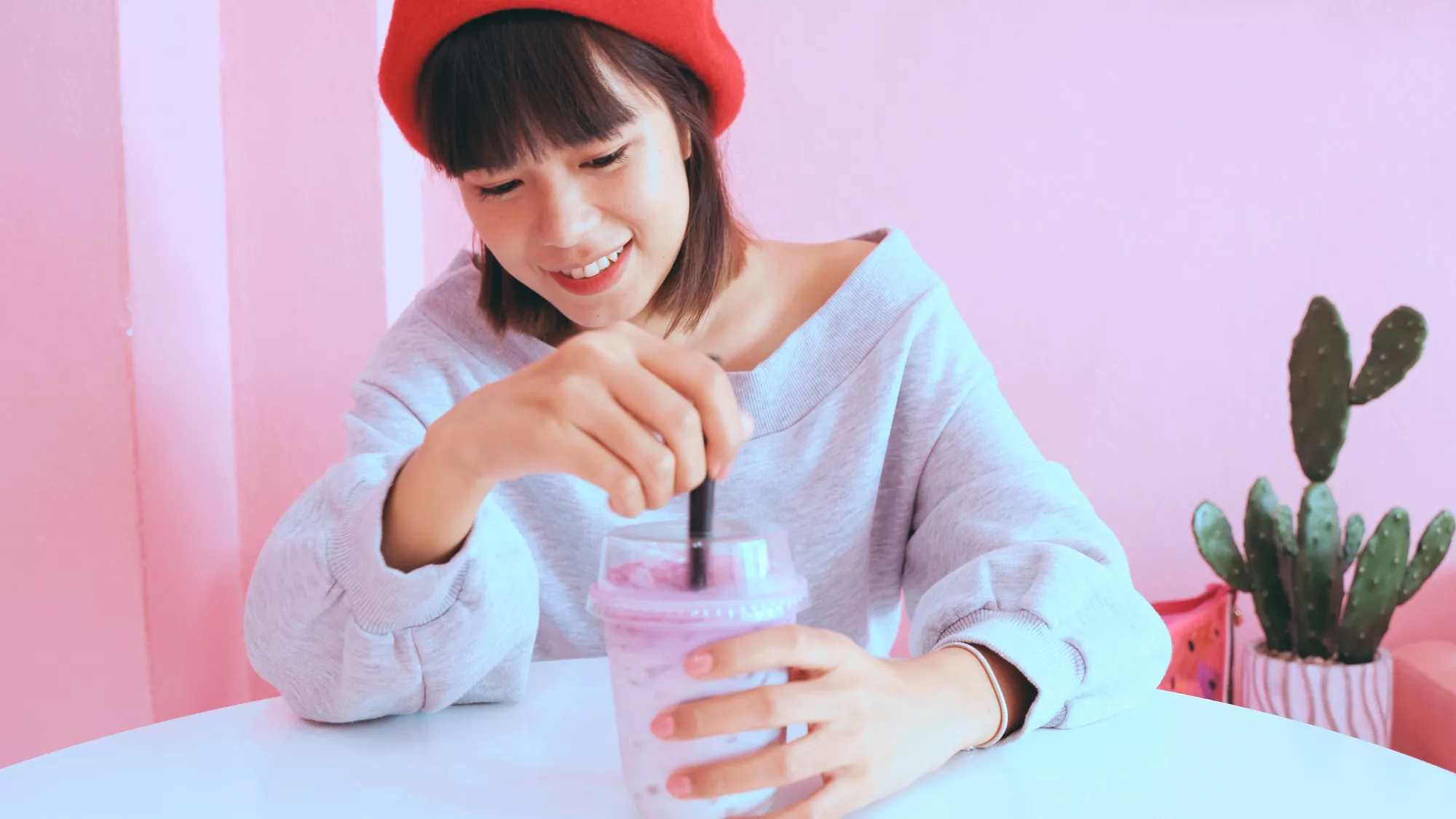 Imagen de una mujer tomando un bubble tea en una cafetería / CANVA