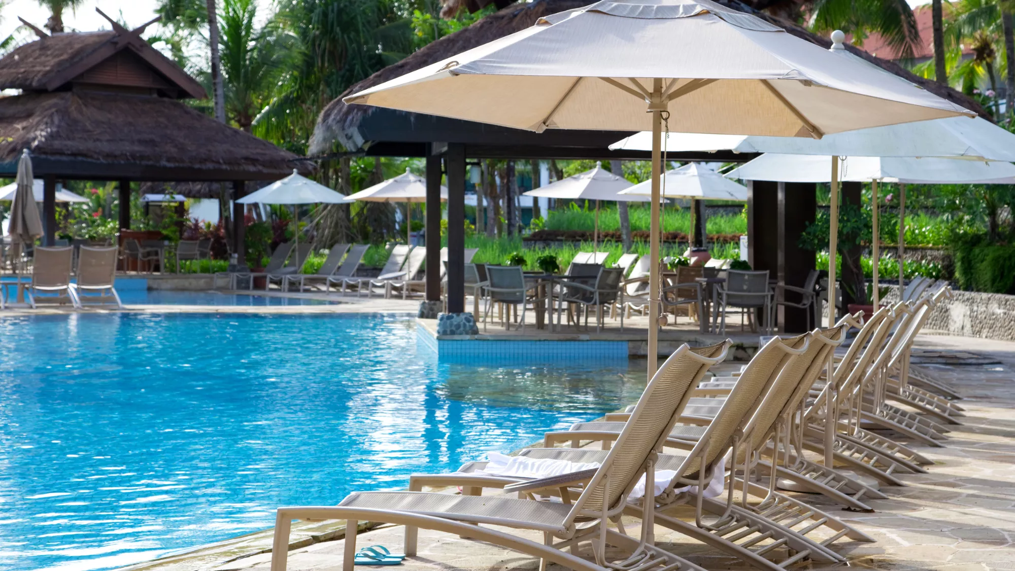 Imagen genérica  de una piscina pública con hamaca y sombrilla / AH