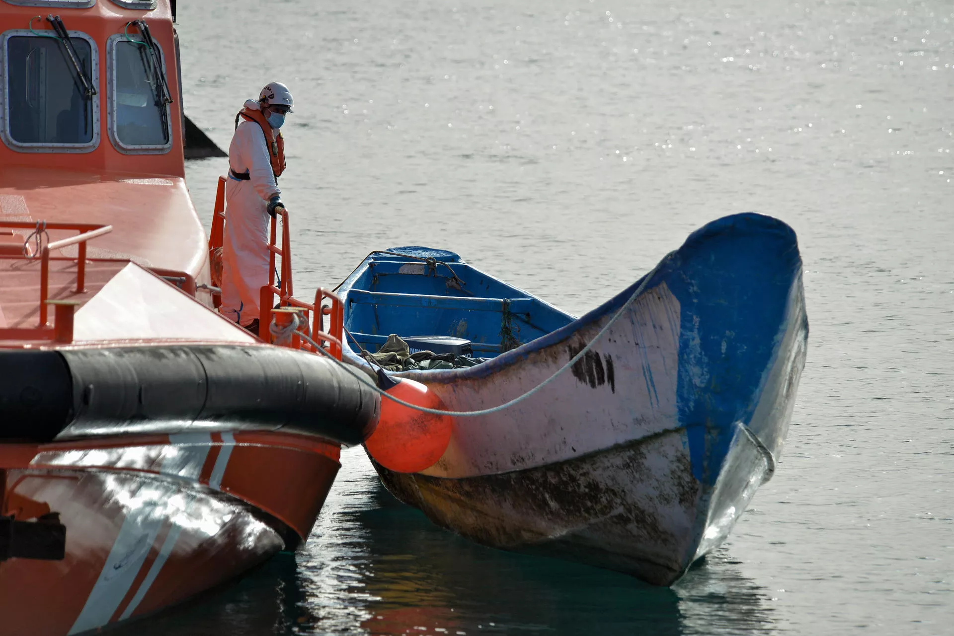 Un cayuco junto a un buque de Salvamento Marítimo. / GELMERT FINOL-EFE