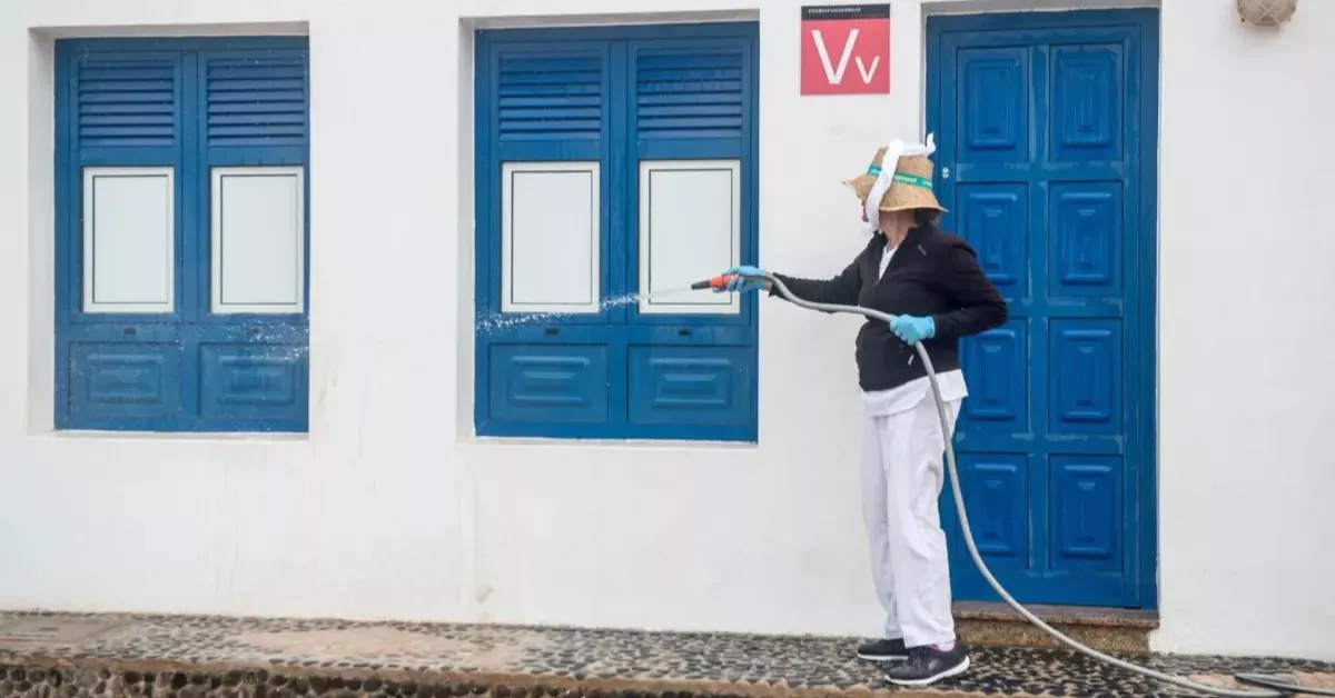 Una mujer limpia con una manguera en La Graciosa / EFE   
