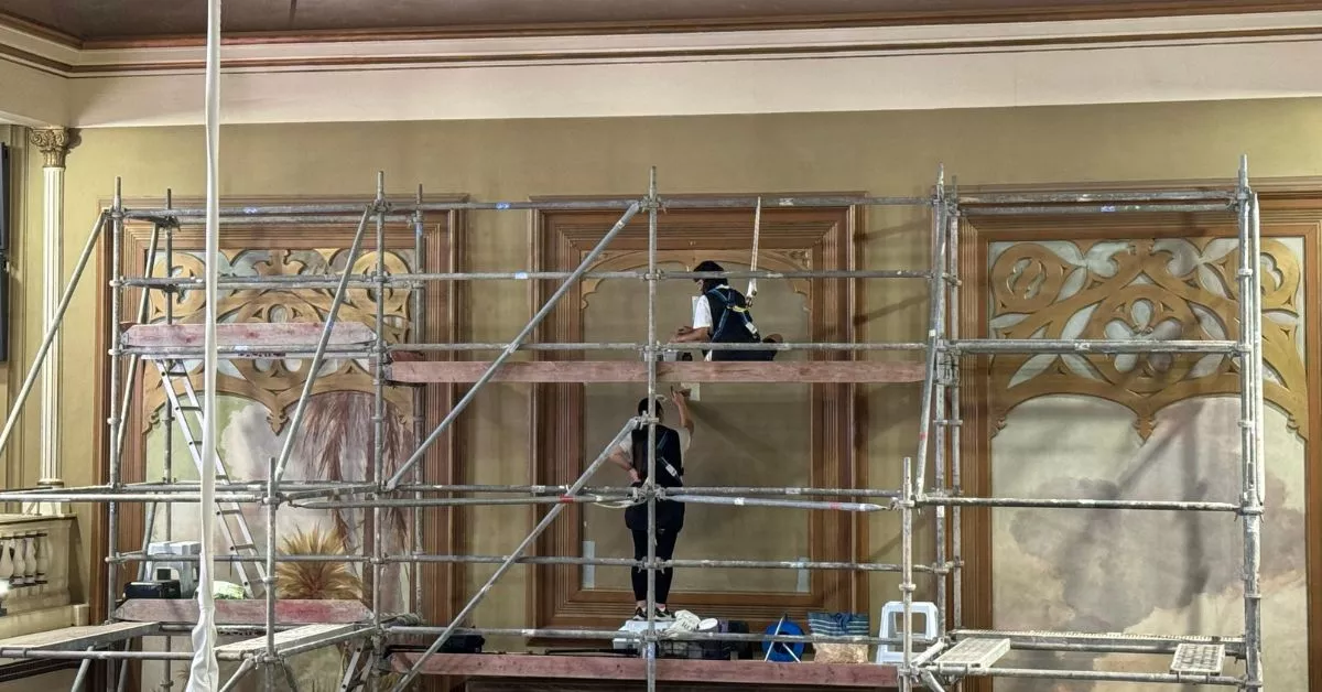 Dos restauradoras trabajan en el lienzo oculto en el salón de plenos del Parlamento de Canarias / CEDIDA