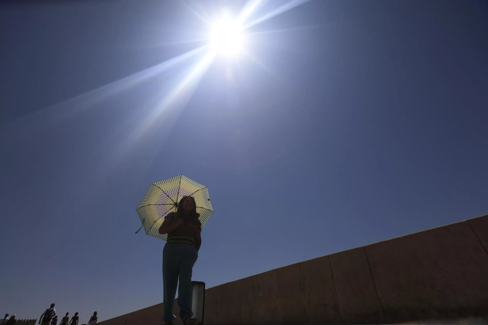 Una mujer se protege del sol con un paraguas. / SALAS-EFE