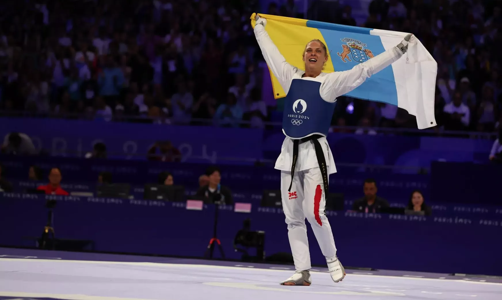 Viviana Marton de Hungría celebra su medalla de oro en Taekwondo con la bandera canaria./EFE/DIVYAKANT SOLANKI