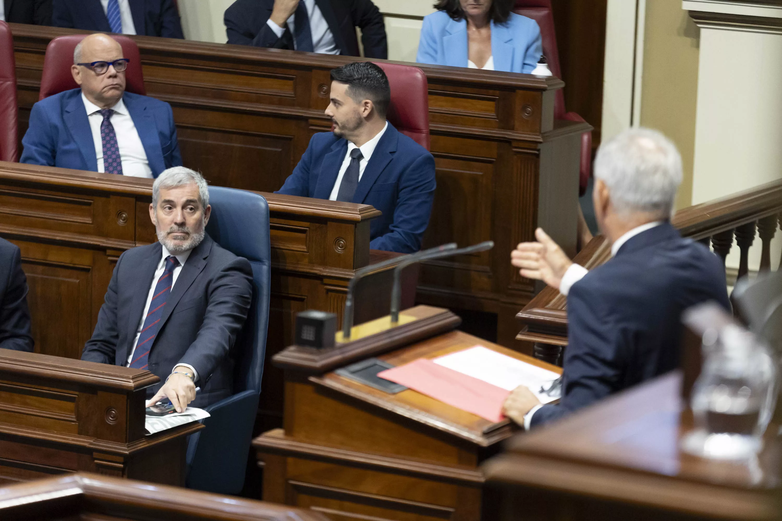 El presidente de Canarias, Fernando Clavijo, escucha la intervención del portavoz del PSOE en el Parlamento autonómico, Sebastián Franquis (d). / MIGUEL BARRETO-EFE