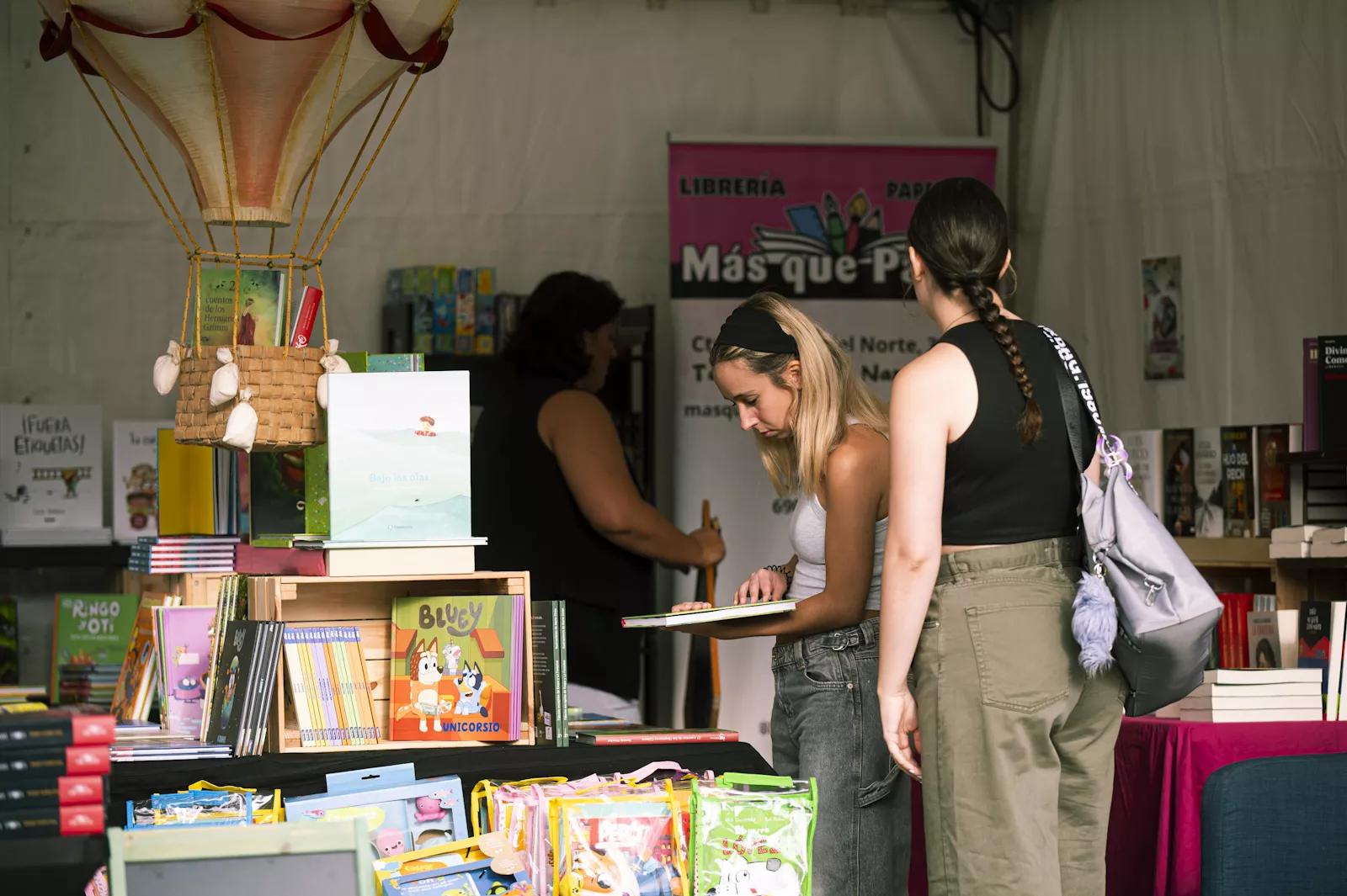 Dos chicas en uno de los puestos de la Feria del Libro de La Laguna. / CEDIDA