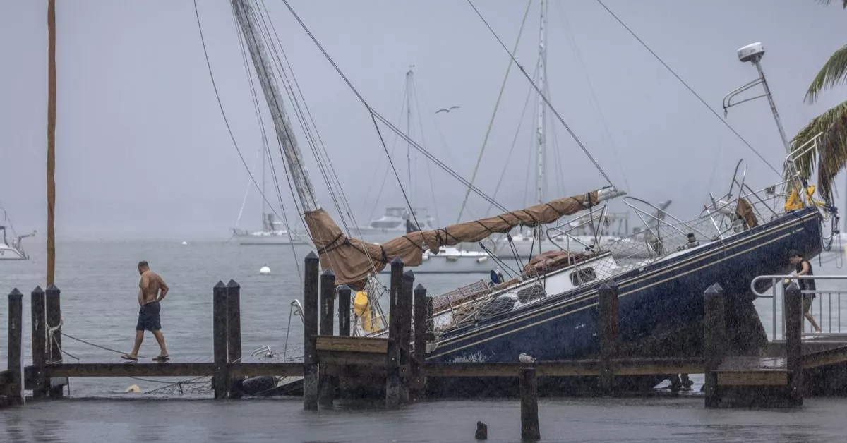 Un hombre frente a un barco destrozado por el huracán Milton / EFE