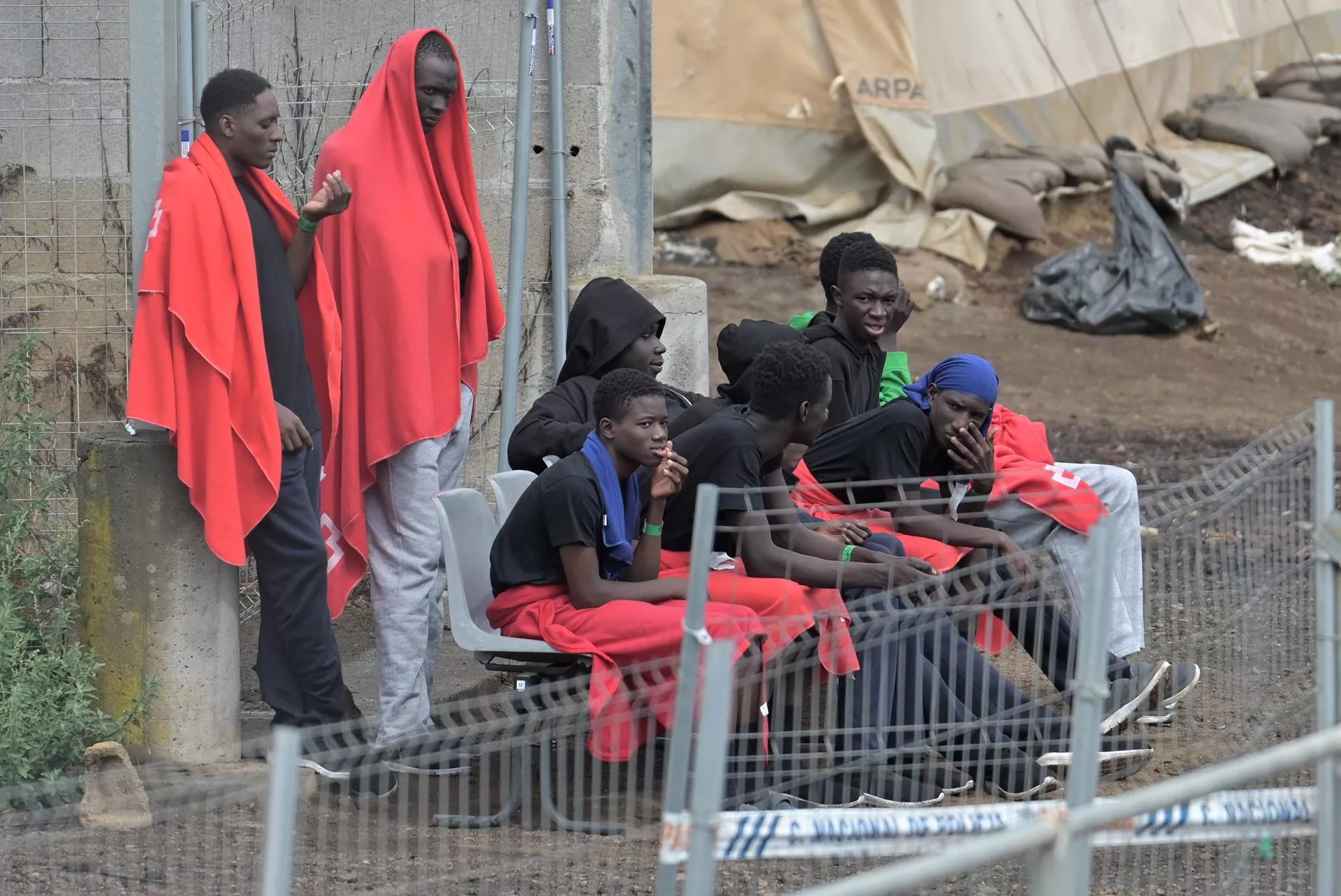 Varios inmigrantes subsaharianos llegados en cayuco a El Hierro conversan en el centro de atención temporal de extranjeros (CATE) de San Andrés, en Valderde. / GELMERT FINOL-EFE