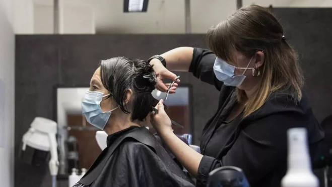 La trabajadora de una peluquería / EFE