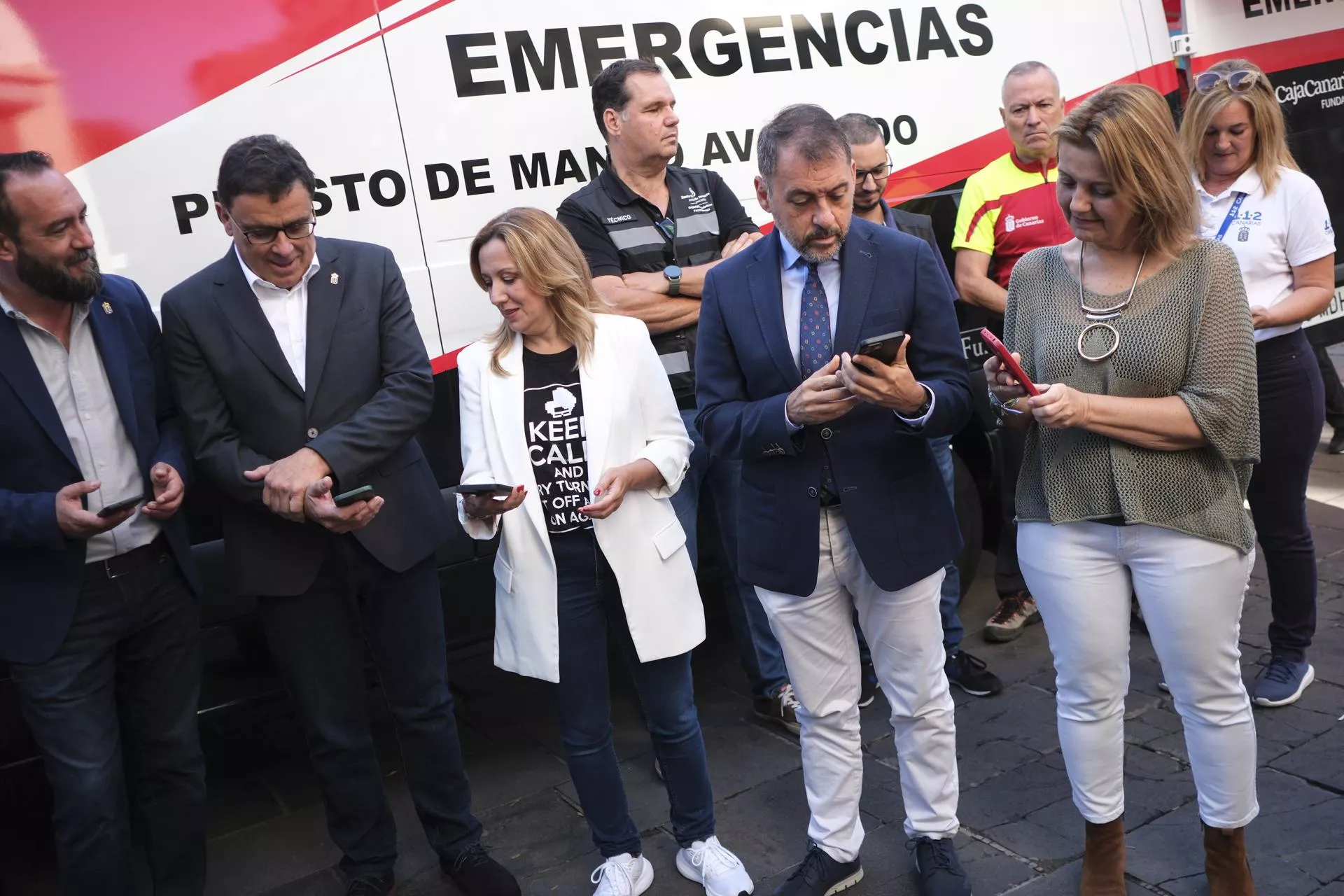 El consejero de Política Territorial, Manuel Miranda; la presidenta del Cabildo de Tenerife, Rosa Dávila, y el alcalde de Santa Cruz, José Manuel Bermúdez, revisan su teléfono móvil después de recibir una alerta del servicio ES-Alert./ EFE