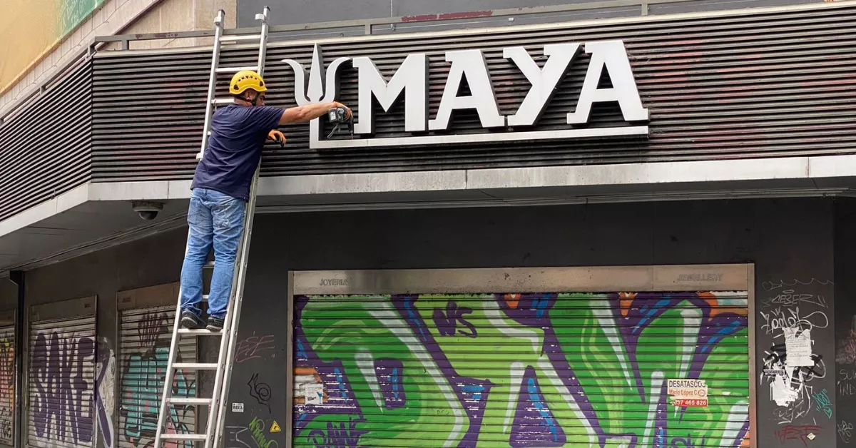 Un voluntario de Insula Signa retira el logo de Maya / INSULA SIGNA