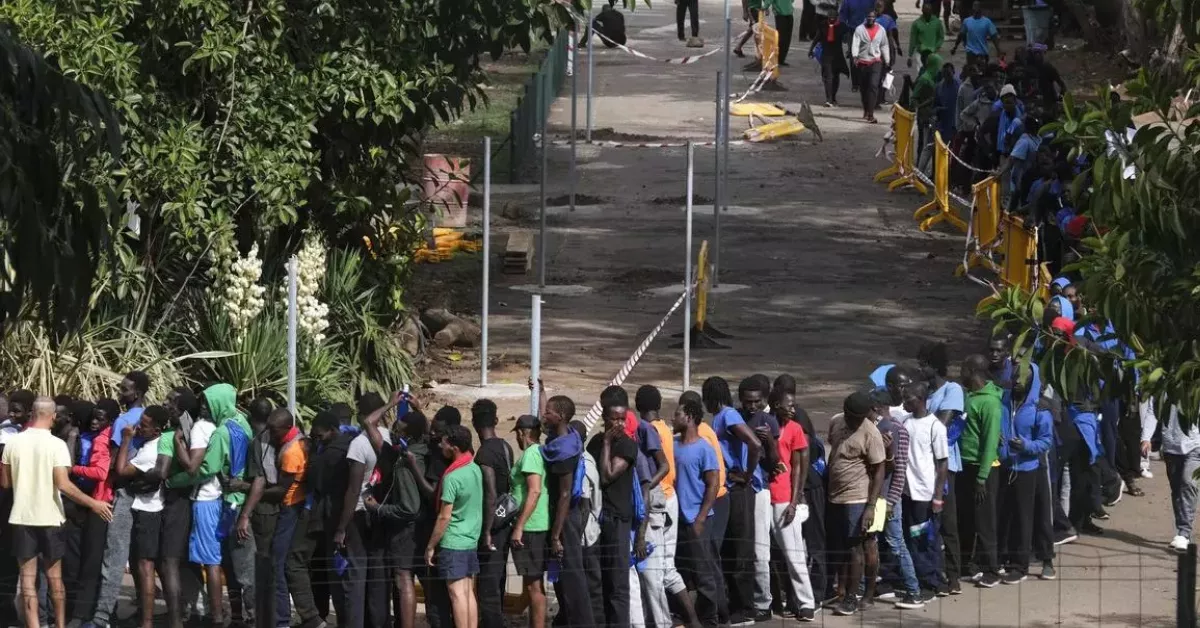 Varias decenas de inmigrantes hacen cola en el interior centro de acogida de Las Raíces, en La Laguna (Tenerife). EFE