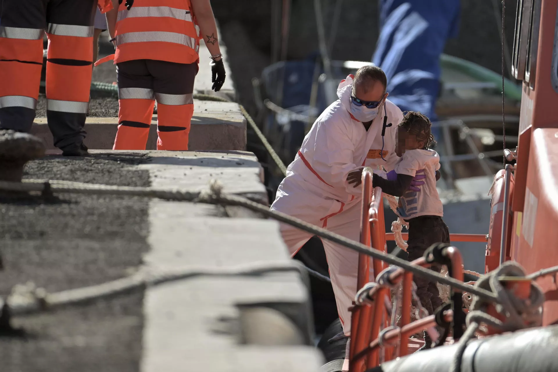 Un sanitario desembarca a un menor en El Hierro de un cayuco. / GELMERT FINOL-EFE