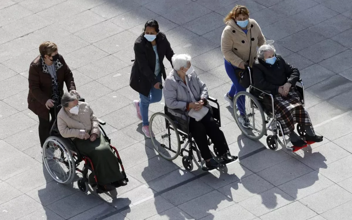 Imagen de archivo de tres mujeres dependientes con sus cuidadoras. / LUIS TEJIDO-EFE