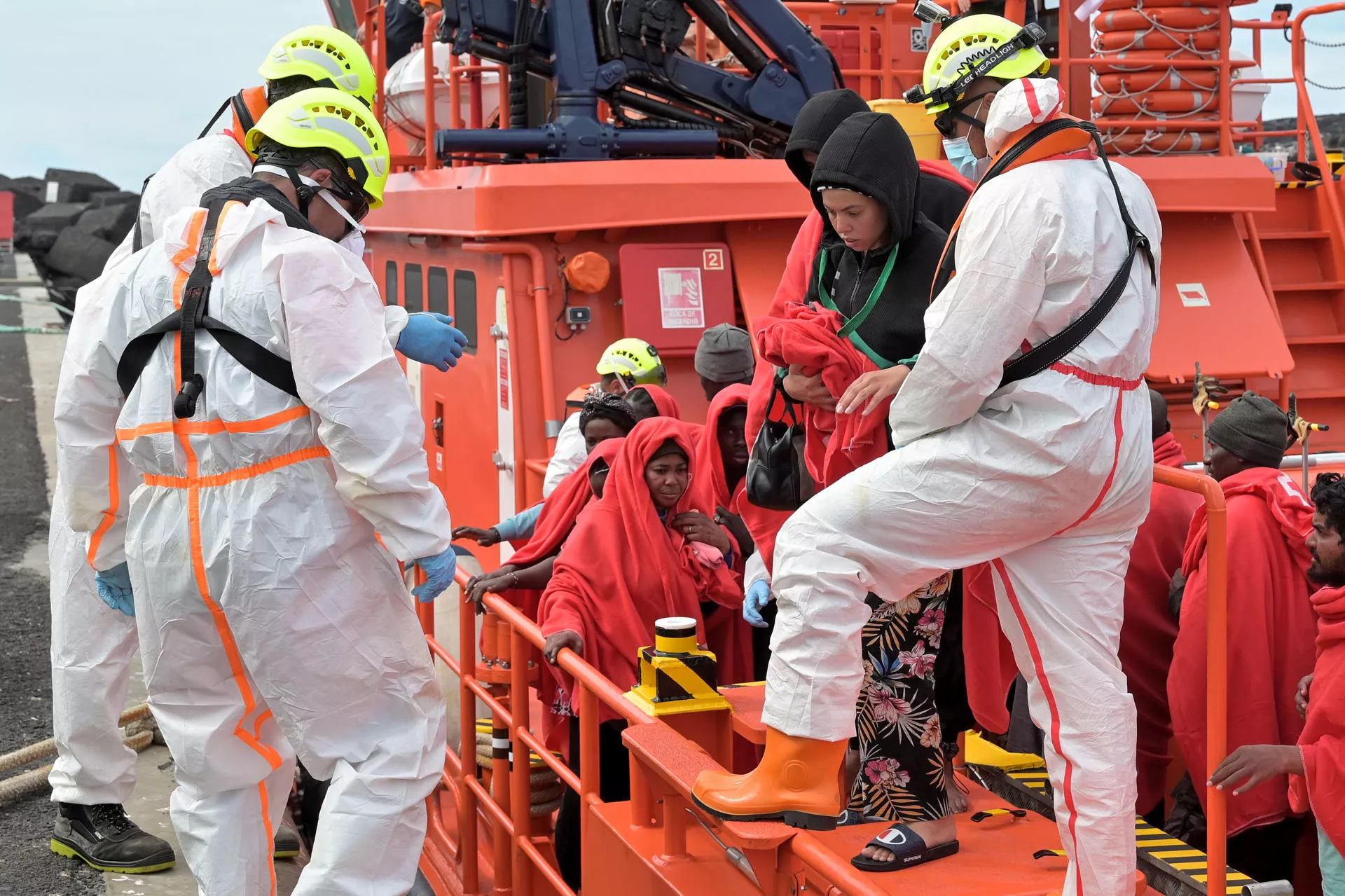 Una mujer, de Bangladés, baja de la 'Salvamar Talía' con dos de los cuatro gatos con los que viajó en el cayuco. / GELMERT FINOL-EFE