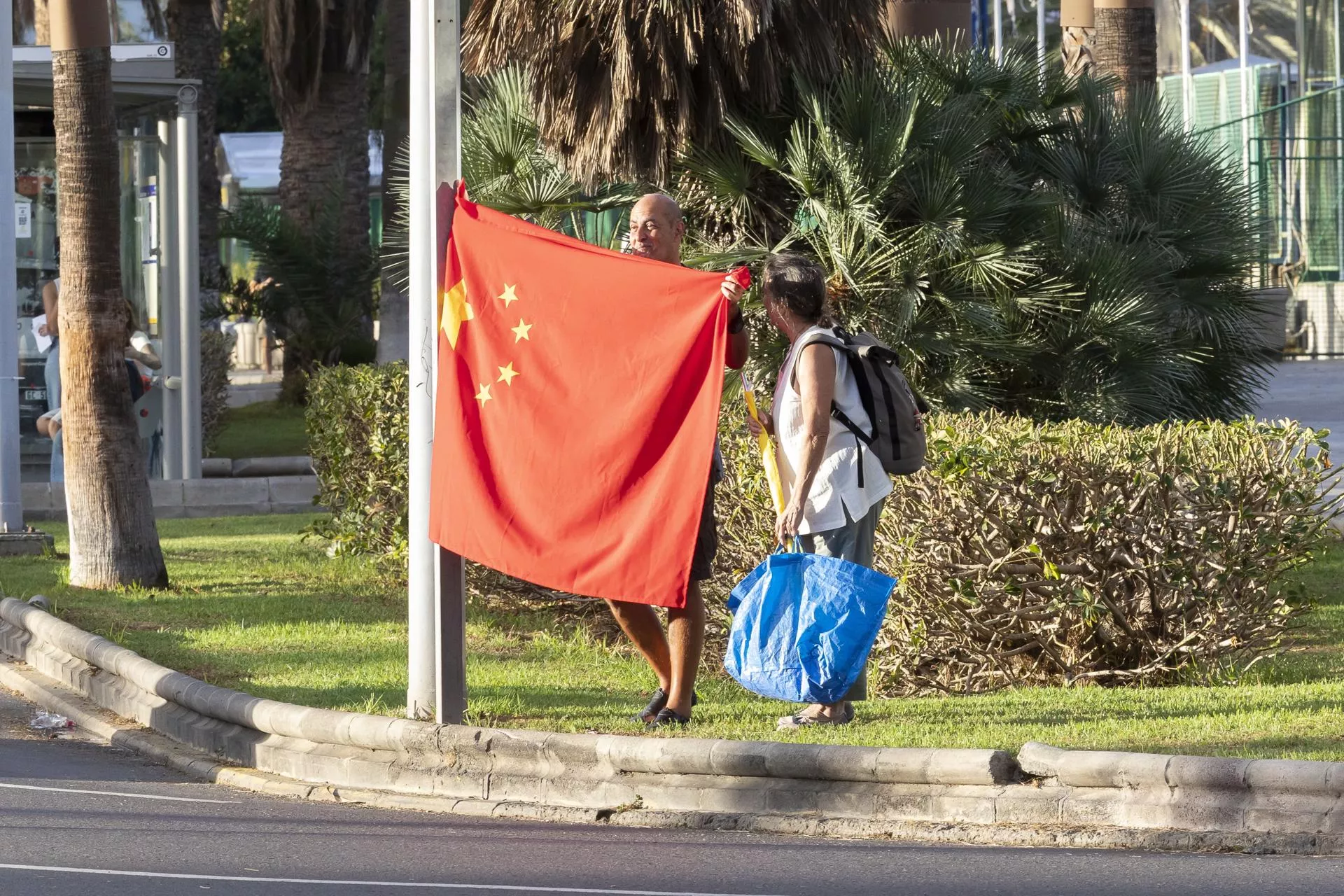 En la imagen, un hombre con una bandera china espera en las inmediaciones del hotel Santa Catalina el paso del mandatario chino. EFE/ Quique Curbelo