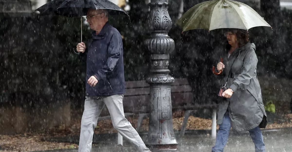 Imagen dos personas caminando bajo la lluvia / EFE