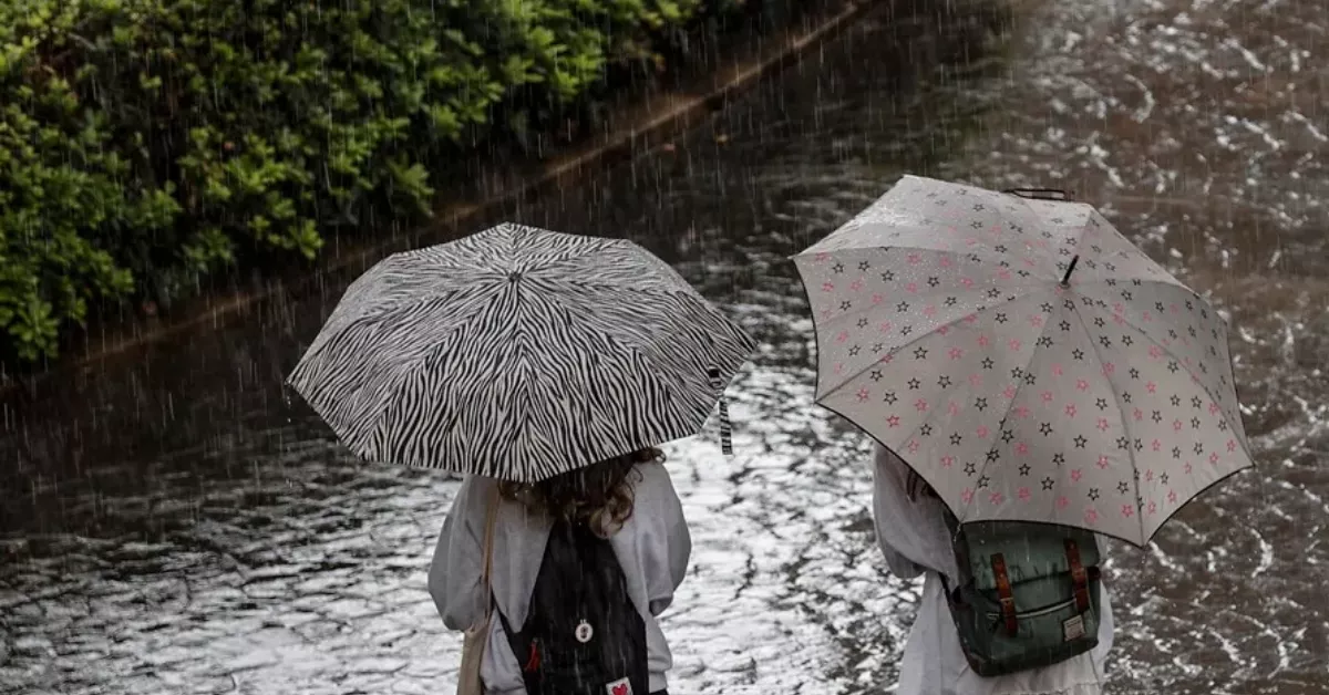Imagen de dos personas bajo la lluvia en un día con tormentas / EFE