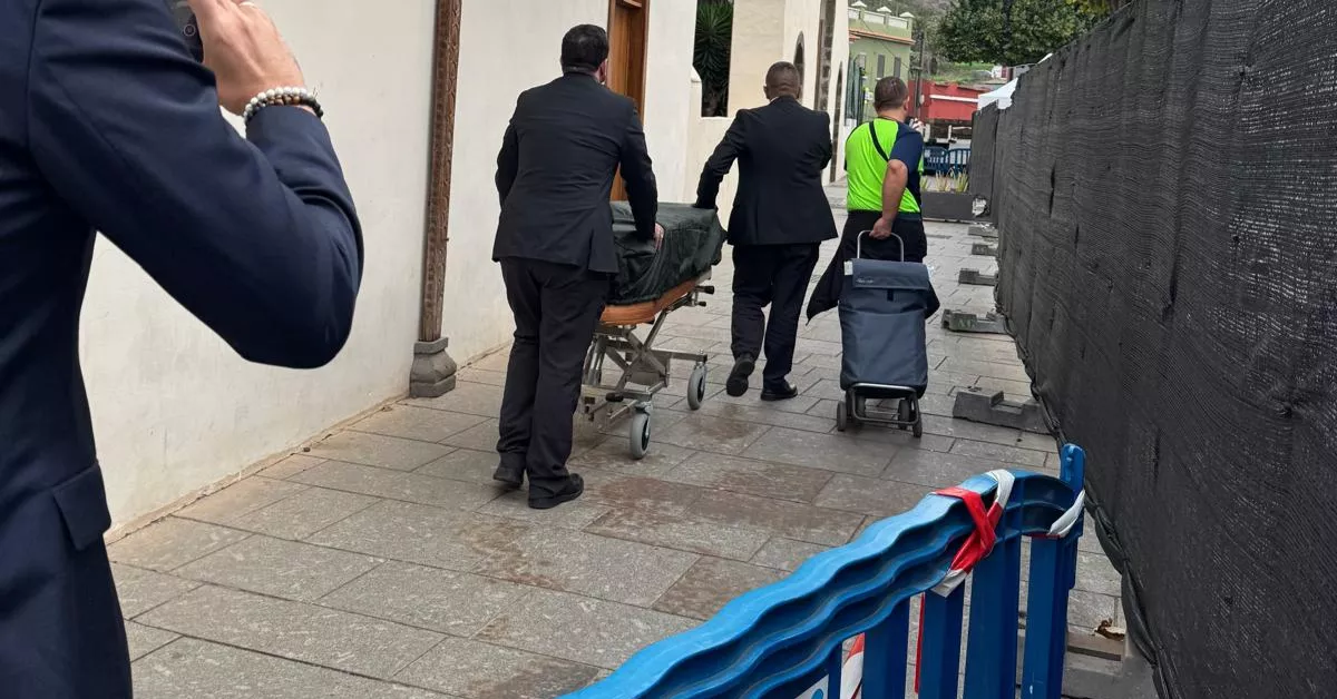 Dos trabajadores de Mémora trasladan un ataúd al coche fúnebre / AH