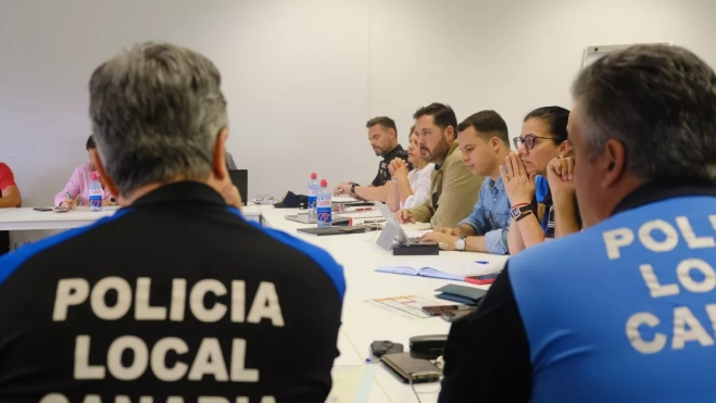 En la imagen, dos agentes de la Policía Local y al fondo, Josué Íñiguez / AYUNTAMIENTO DE LAS PALMAS