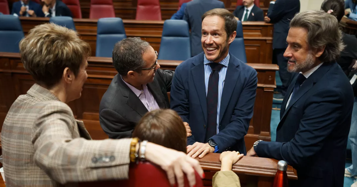 El consejero de Transición Ecológica y Energía del Gobierno de Canarias, Mariano Zapata (2d) ,conversa con varios diputados del grupo socialista durante el pleno del Parlamento de Canarias. / EFE