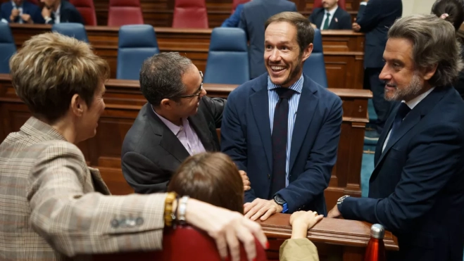 El consejero de Transición Ecológica y Energía del Gobierno de Canarias, Mariano Zapata (2d) ,conversa con varios diputados del grupo socialista durante el pleno del Parlamento de Canarias. / EFE