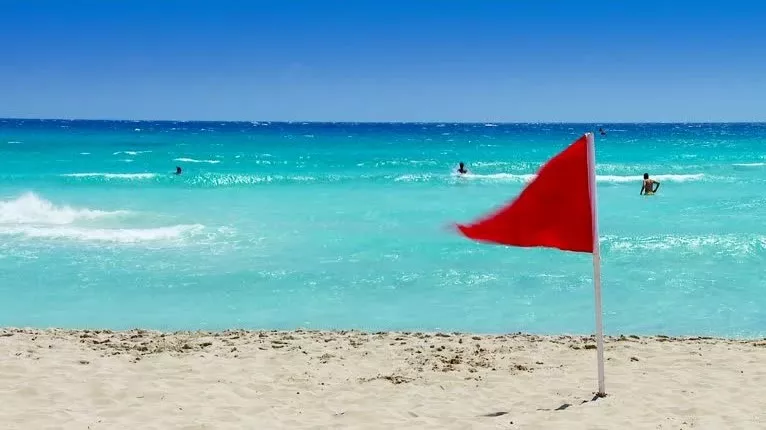 Imagen una playa con bandera roja para evitar ahogamiento. / CEDIDA