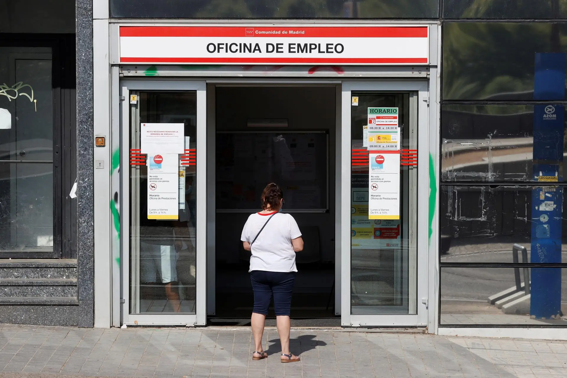 Una mujer espera en la puerta de una oficina de empleo, en una imagen de archivo. / EFE - JUAN CARLOS HIDALGO 