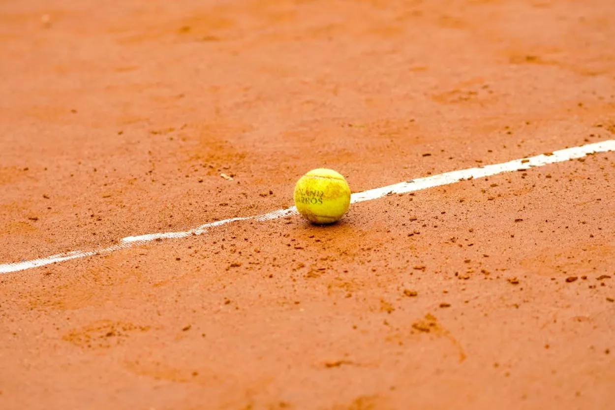 Tierra batida y pelota de Tenis / PEXELS