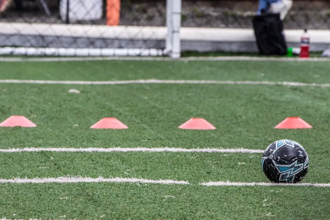 Campo de entrenamiento de fútbol con conos y balón / PEXELS