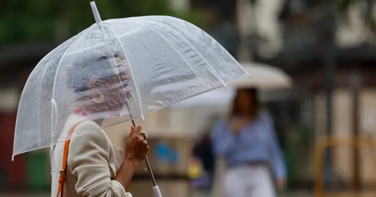 Imagen de una mujer con un paraguas por las lluvias / EFE