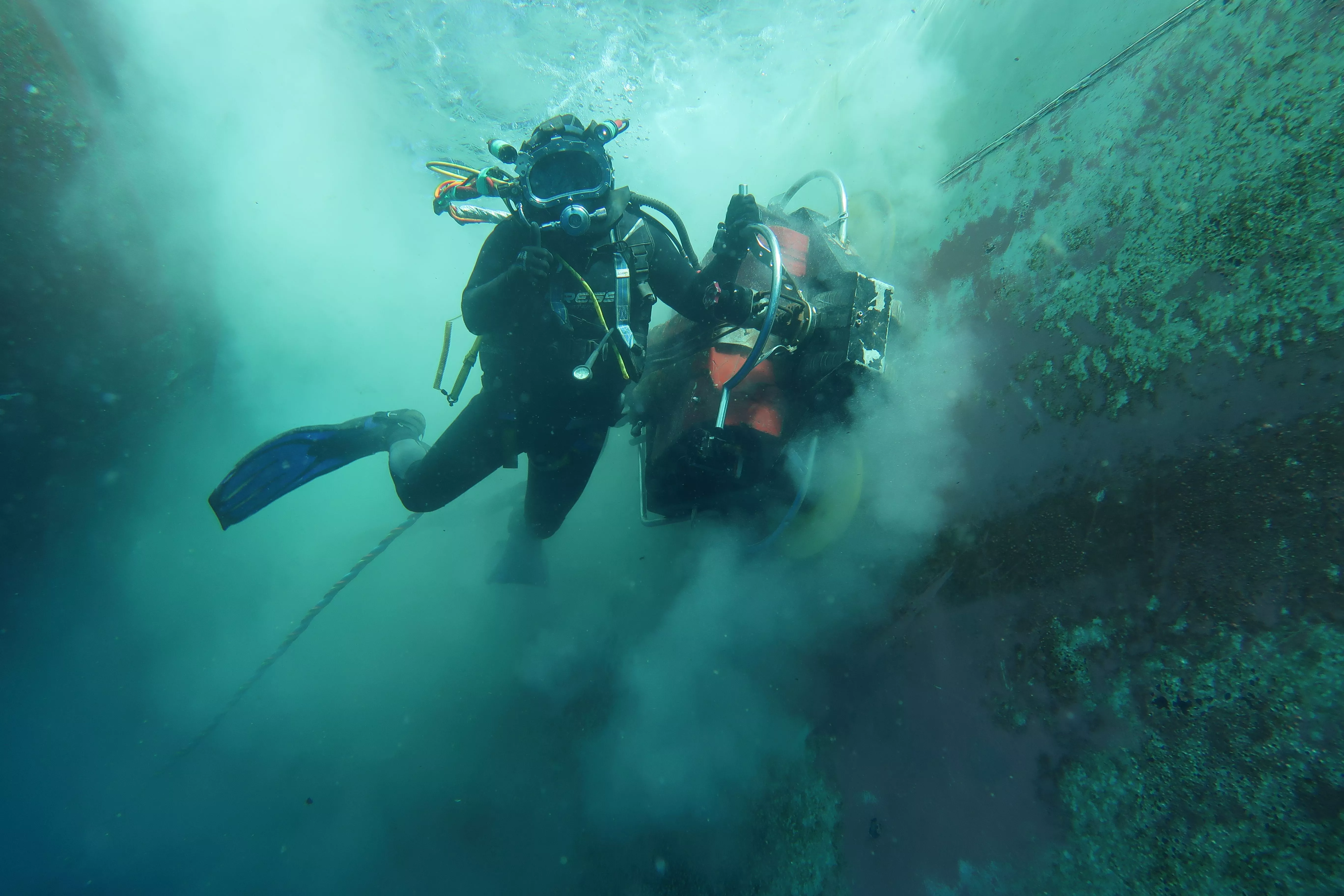 Un buceador de Reprosub limpia el casco de un buque en el Puerto de Las Palmas. / ATLÁNTICO HOY