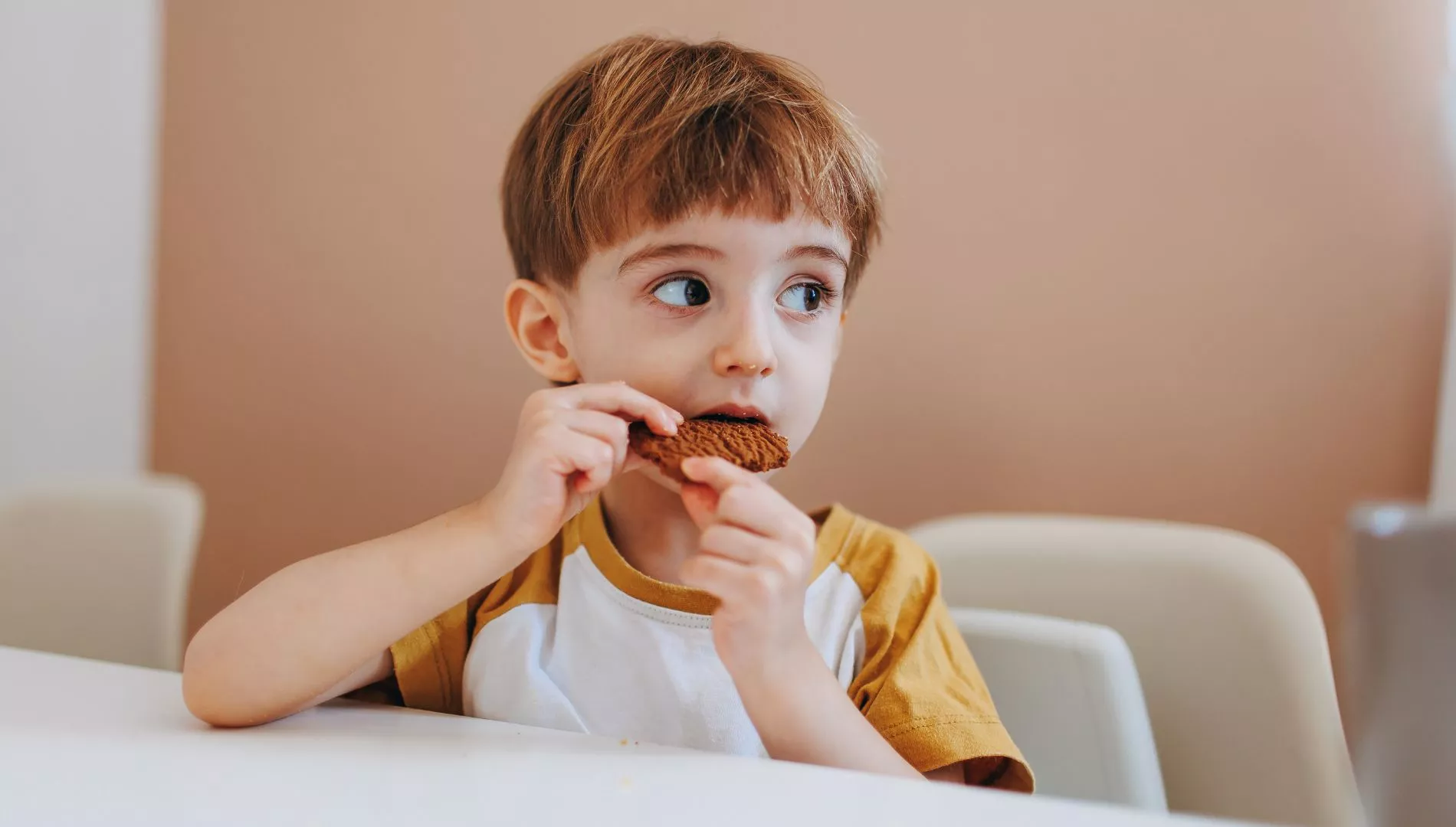 Imagen de archivo de un niño comiendo un dulce / Canva
