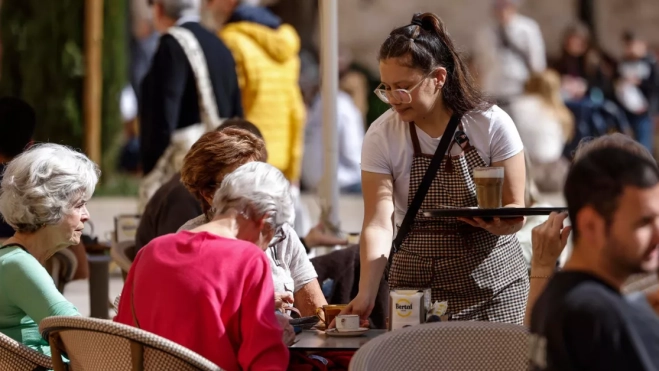Una joven camarera sirve una mesa / EFE 