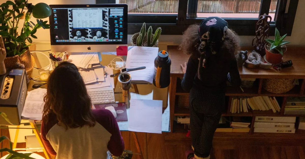Una mujer teletrabaja junto a su hija / EFE