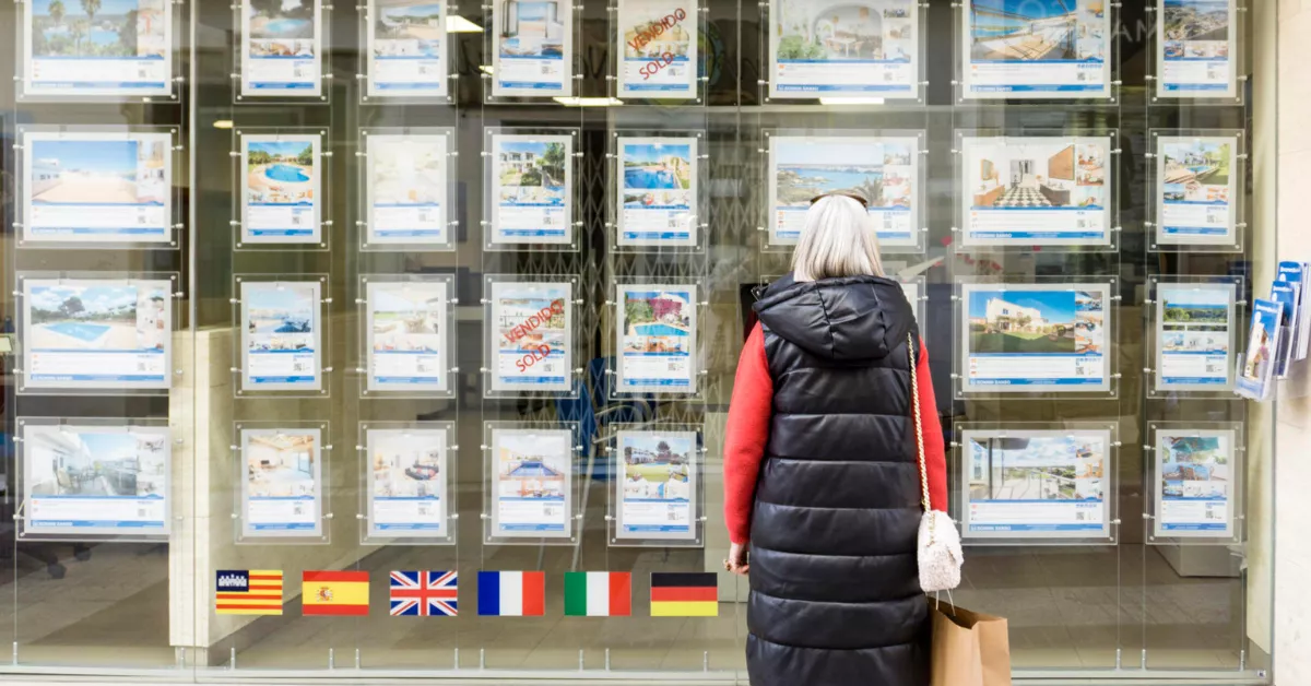 Una mujer mira el escaparate de una inmobiliario / EFE