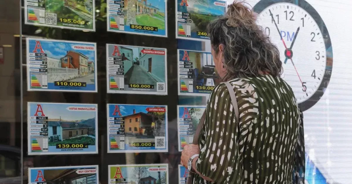 Una mujer mira el escaparate de una inmobiliaria en Las Palmas con precios de viviendas / EFE