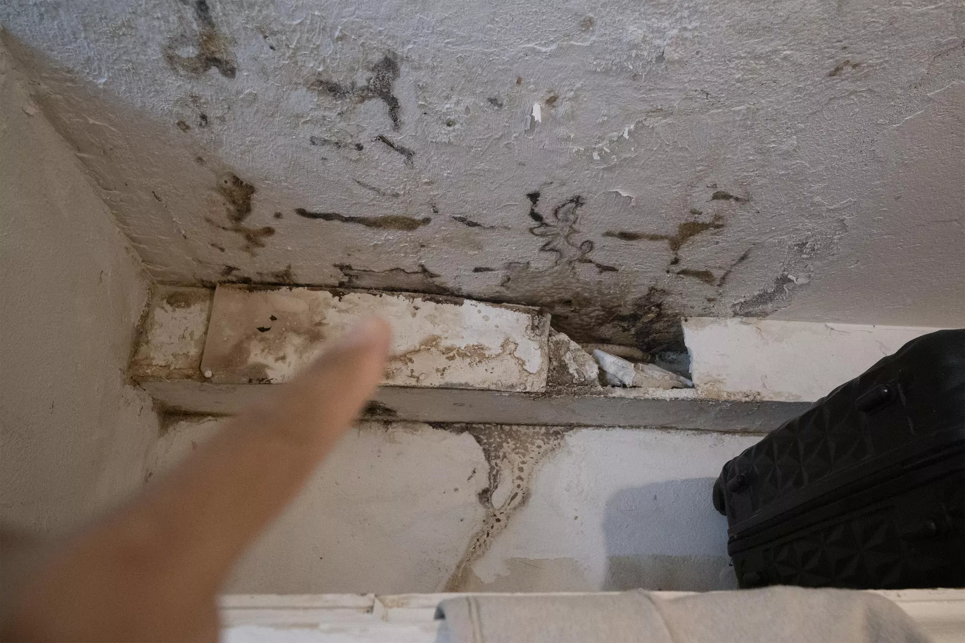 En la imagen, uno de los inquilinos del inmueble muestra las humedades del techo. EFE/Adriel Perdomo