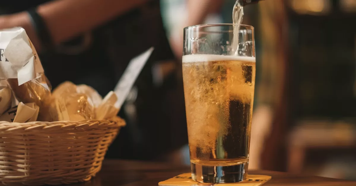 Imagen de una persona en tomando cerveza en un bar / UNSPLASH