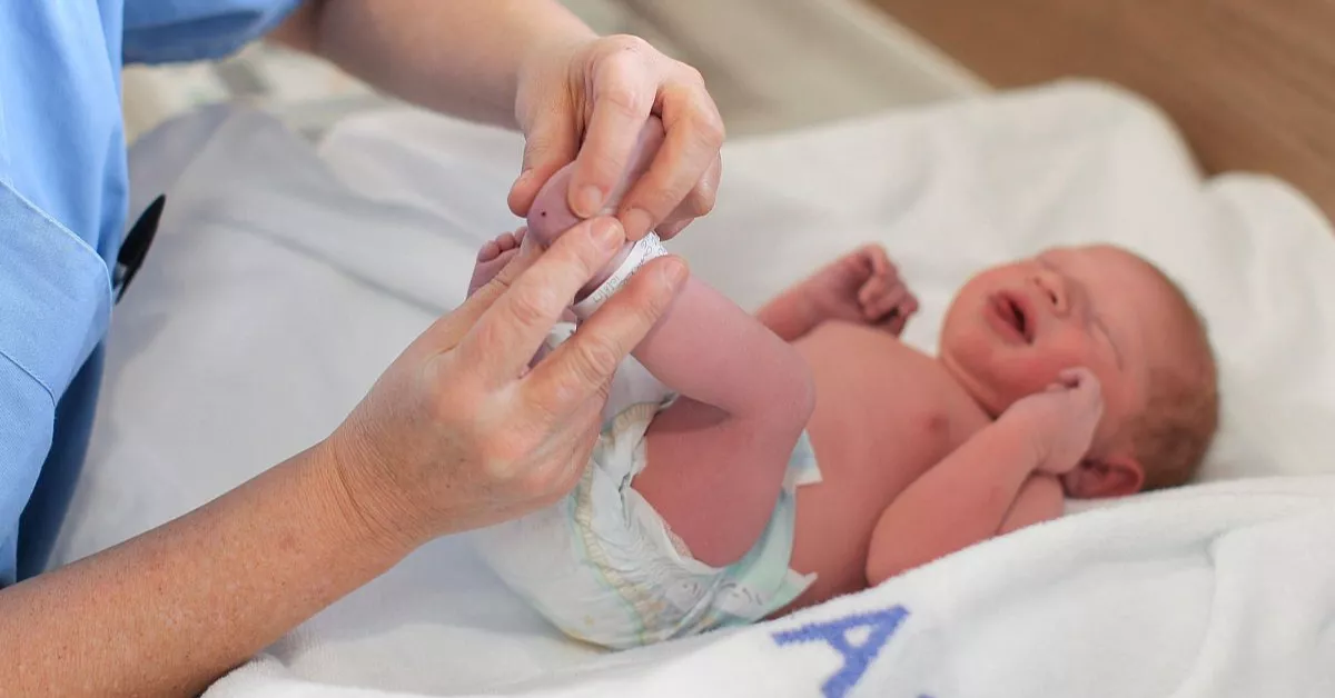 Una sanitaria realiza la prueba del talón a un bebé para la detección de enfermedades raras. 