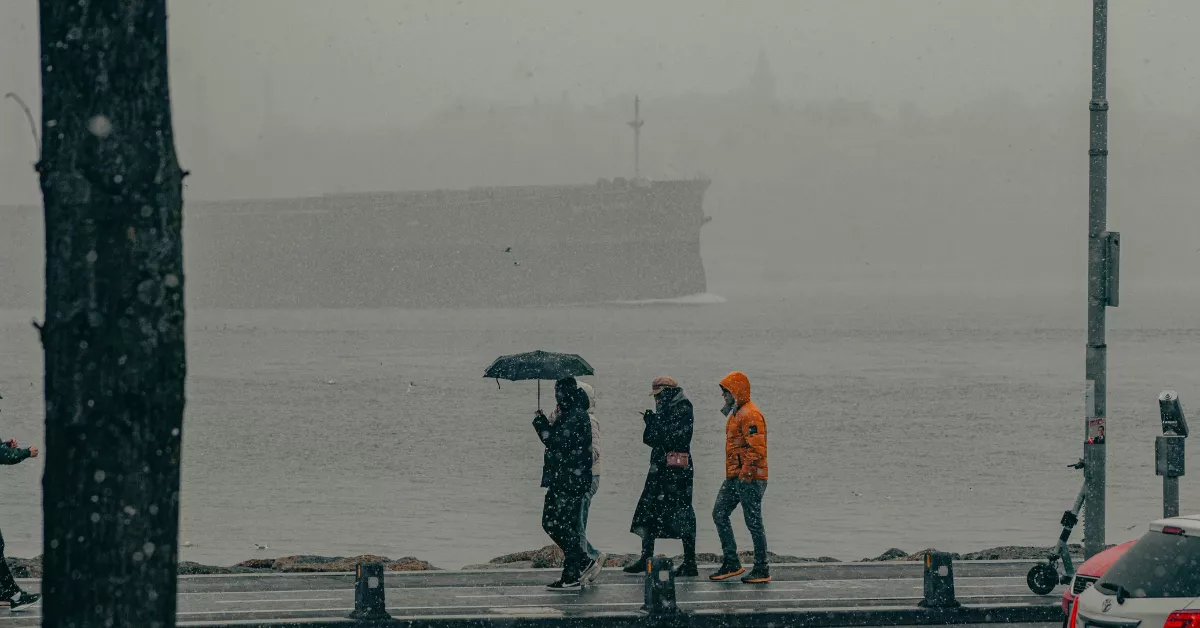 Imagen de tres personas paseando y lidiando con el frío / PEXELS