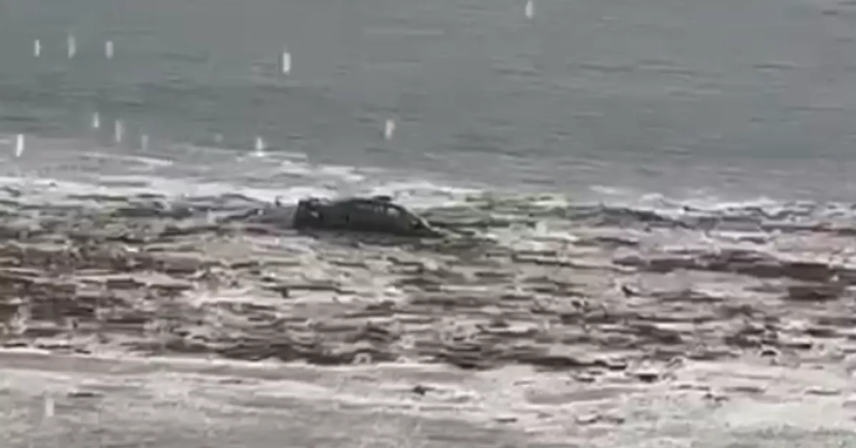 El mar engulle un coche que fue arrastrado por una riada hasta la playa de Salinetas, en Telde./ AH