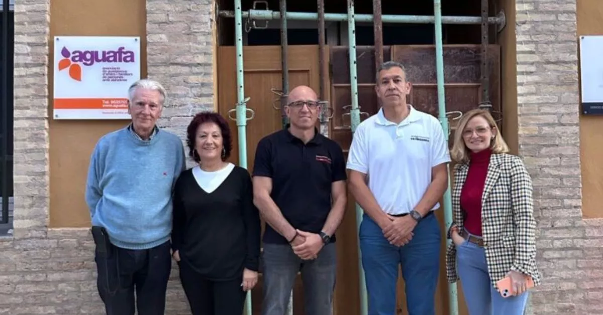 Los estibadores Francisco Ramos y Rayco del Rosario, en el centro de la imagen, durante la visita al centro de personas con alzheimer AFA Guadassuar. / FEVAFA