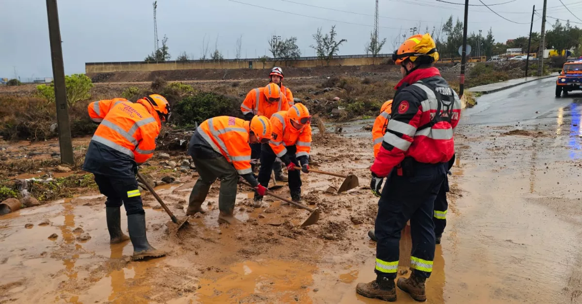 Protección civil y bomberos quitando lodo de una carretera en Ojos de Garza, Telde./ ATYO. TELDE