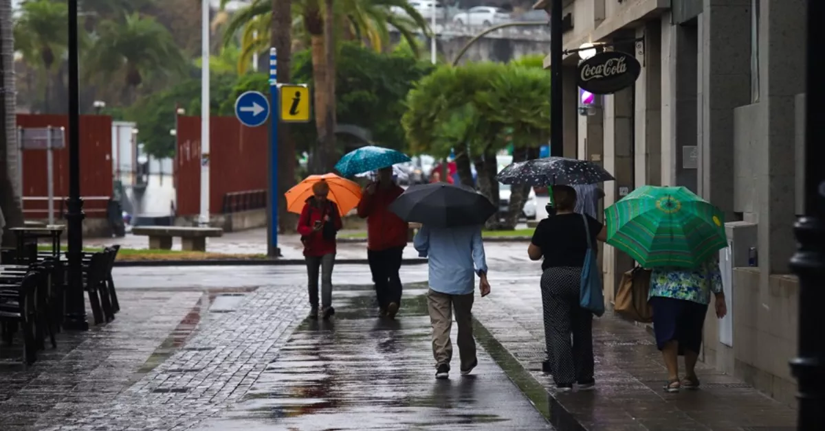 Imagen de personas caminando bajo la lluvia en Canarias / EFE - LUIS G. MORERA